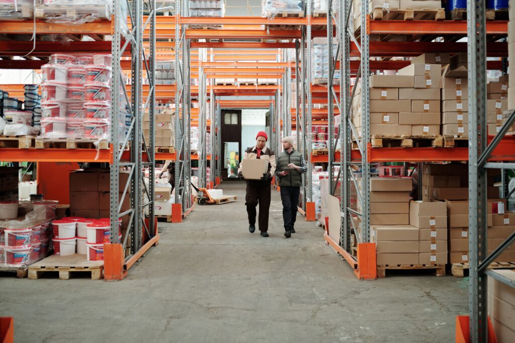 Warehouse staff moving inventory through organized storage aisles, showcasing strategies to improve warehouse efficiency