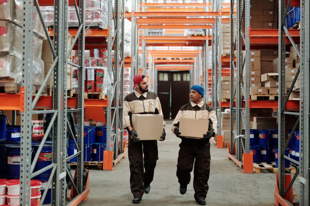 Warehouse staff handling inventory in storage aisles, illustrating coordinated fulfillment operations and workflows