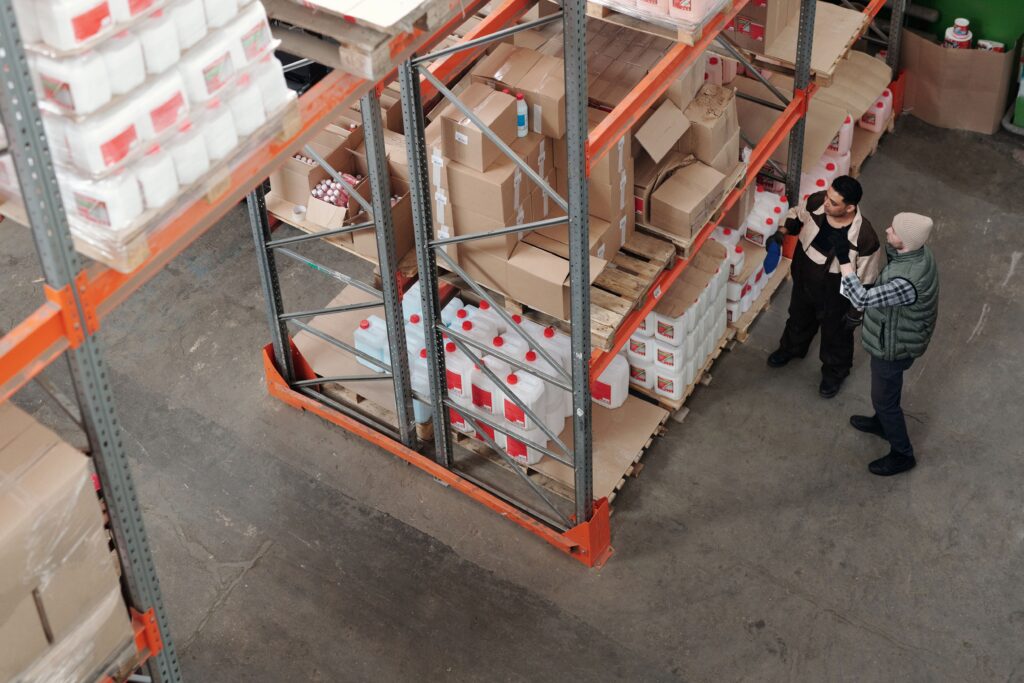 Warehouse management challenges highlighted by staff coordinating inventory across crowded storage racks and pallets