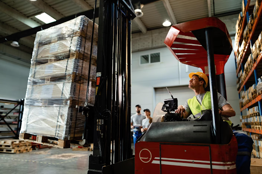 Forklift operator loading cargo while working in a warehouse