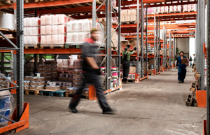 Warehouse workers moving through storage aisles