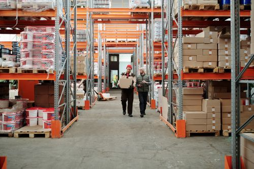Warehouse staff moving inventory through organized storage aisles