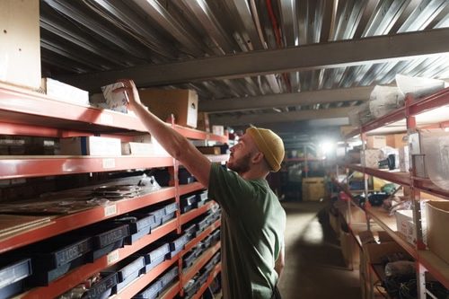 Warehouse worker retrieving inventory from storage racks to improve picking efficiency and accuracy