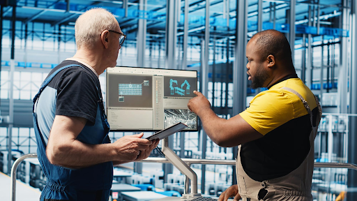 Warehouse workers reviewing data on screen