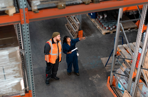 Warehouse workers reviewing inventory on storage racks