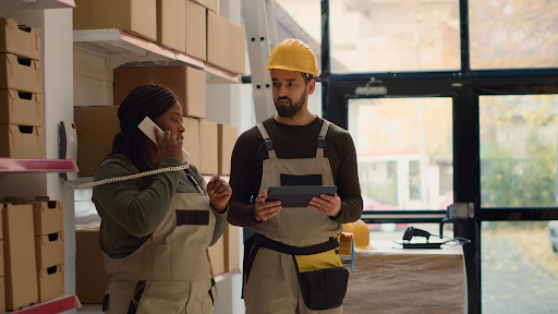 Warehouse workers reviewing labor performance data during a shift