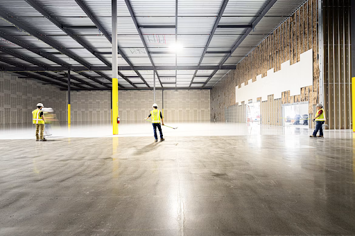 Workers preparing a spacious warehouse floor