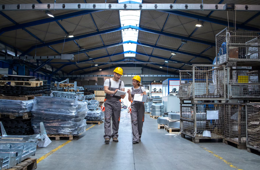 Factory workers walking through large production hall 