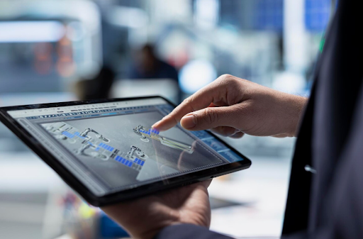 Warehouse professional using a tablet to review a digital warehouse simulation