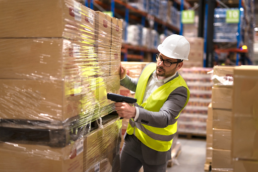 Warehouse worker scanning pallet inventory to identify bottlenecks