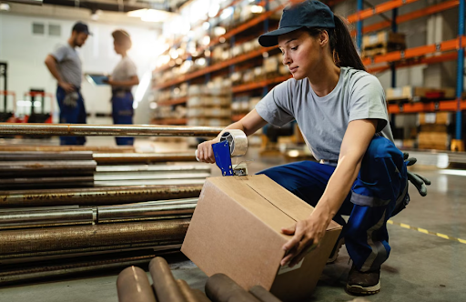 Warehouse worker taping cardboard box