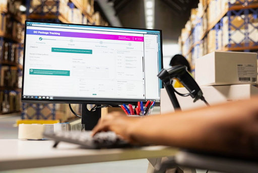 Warehouse worker using a package tracking dashboard to monitor shipments and deliveries